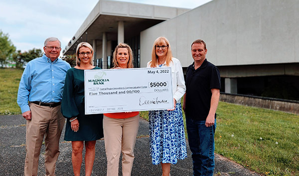 Five people holding a large scholarship cardboard check